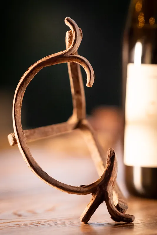 The original C-Bar branding iron, standing on the bar beside a bottle of wine